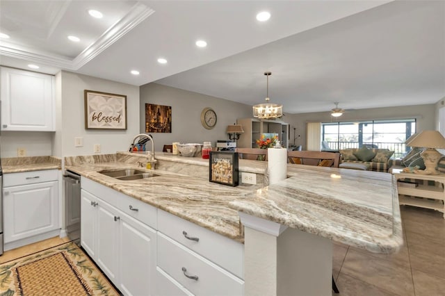 kitchen with a kitchen breakfast bar, stainless steel dishwasher, white cabinetry, and sink