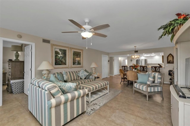 living room with ceiling fan with notable chandelier