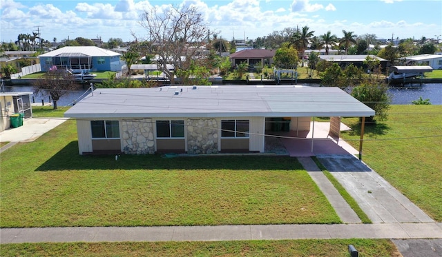 view of front of home with a water view, a front yard, and a carport