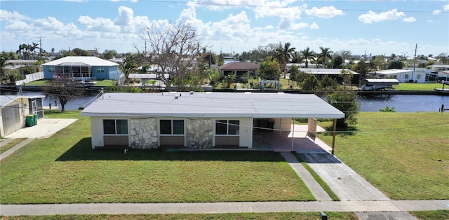 view of front of property featuring a water view, a front lawn, and a carport