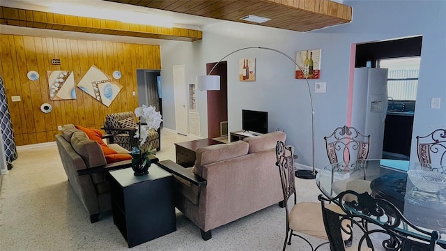 living room featuring wood walls, wooden ceiling, and beam ceiling