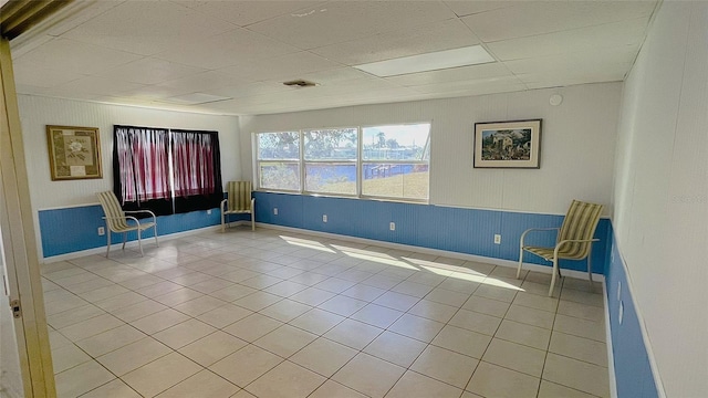 unfurnished room featuring a drop ceiling and tile patterned floors