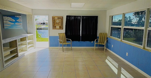 unfurnished room with a drop ceiling and tile patterned floors