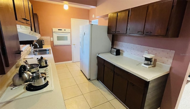 kitchen with tasteful backsplash, ventilation hood, light tile patterned floors, sink, and white appliances