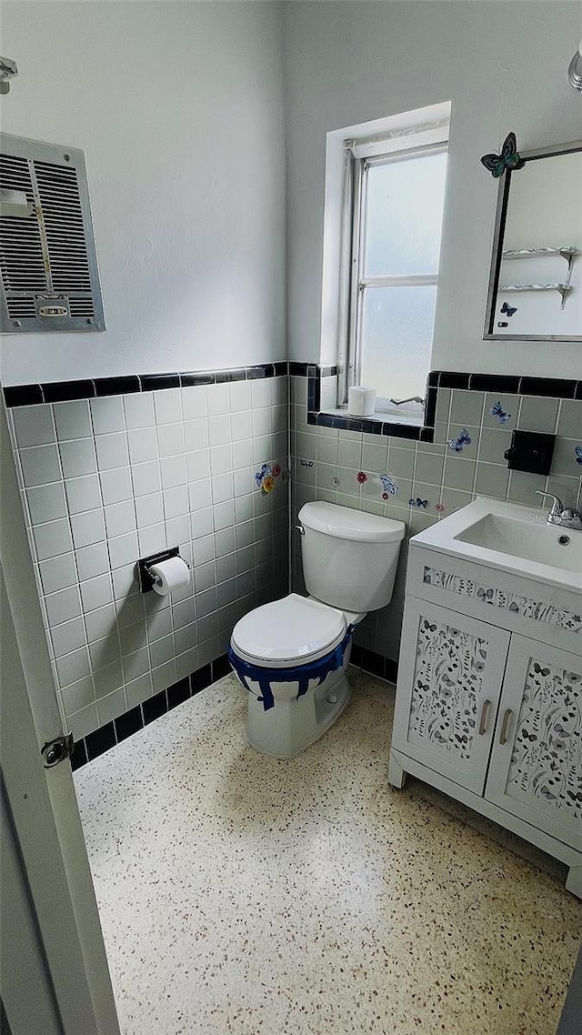554 Lindley Ter, Port Charlotte, FL 33952 - bathroom with tile walls, toilet, wainscoting, and vanity