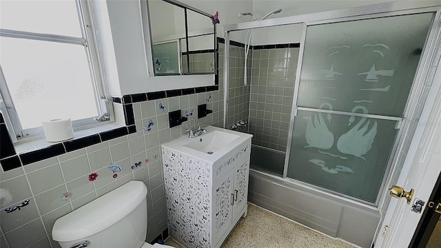 554 Lindley Ter, Port Charlotte, FL 33952 - full bath with speckled floor, shower / bath combination with glass door, toilet, a sink, and tile walls