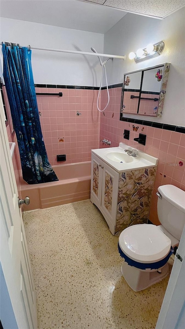 bathroom featuring tile walls, toilet, and shower / tub combo