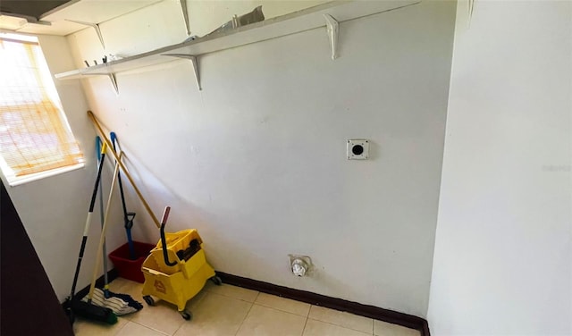 laundry area with light tile patterned flooring, electric dryer hookup, and a healthy amount of sunlight