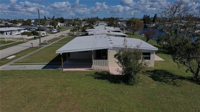 554 Lindley Ter, Port Charlotte, FL 33952 - back of property featuring a residential view, a lawn, a water view, and an attached carport