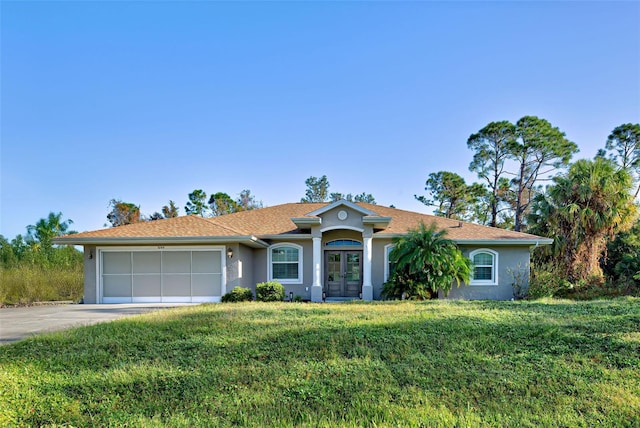 ranch-style home with french doors, a front yard, and a garage