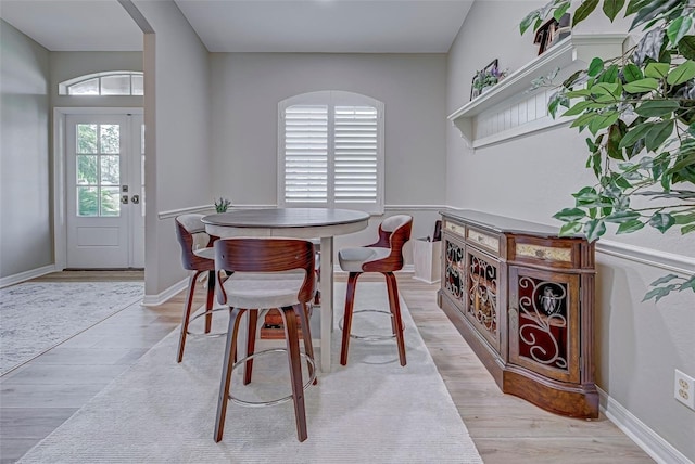 dining space featuring a wealth of natural light, light hardwood / wood-style flooring, and lofted ceiling