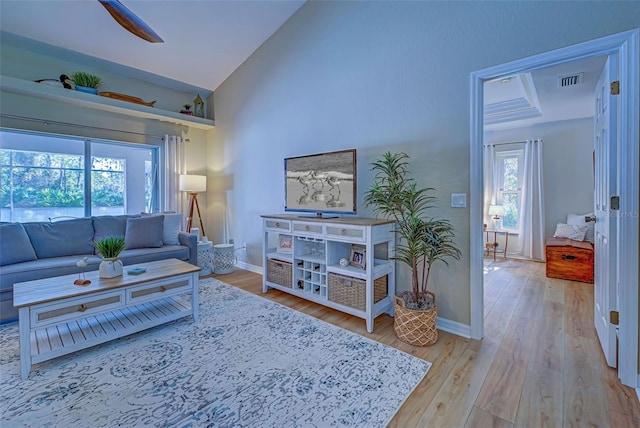 living room with hardwood / wood-style flooring, high vaulted ceiling, and ceiling fan