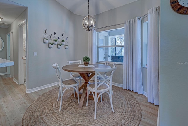 dining room featuring light wood-type flooring and an inviting chandelier