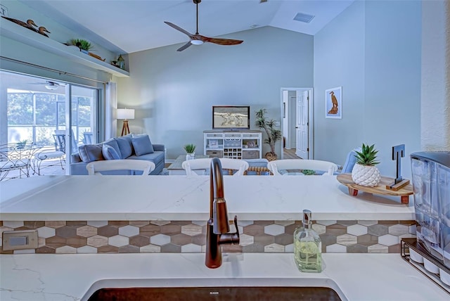 interior space featuring ceiling fan, sink, and vaulted ceiling