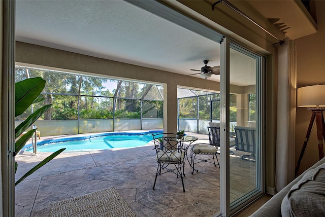 view of swimming pool featuring a lanai, ceiling fan, and a patio