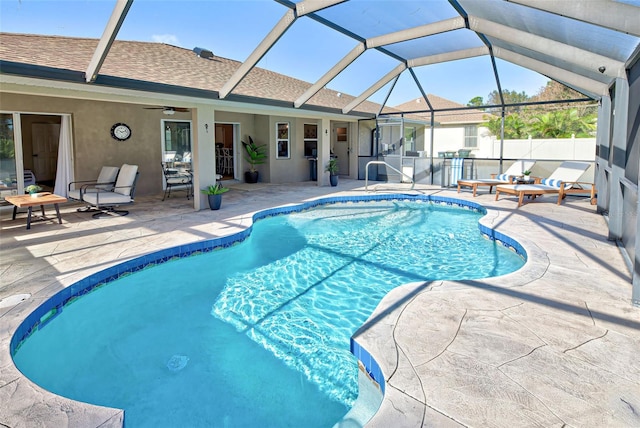 view of pool with glass enclosure, ceiling fan, and a patio