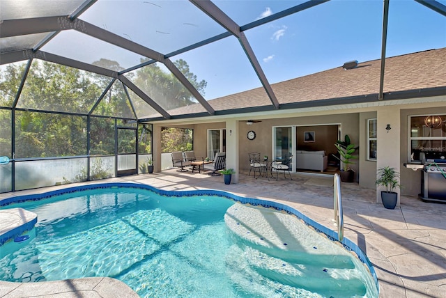 view of pool featuring glass enclosure, ceiling fan, and a patio