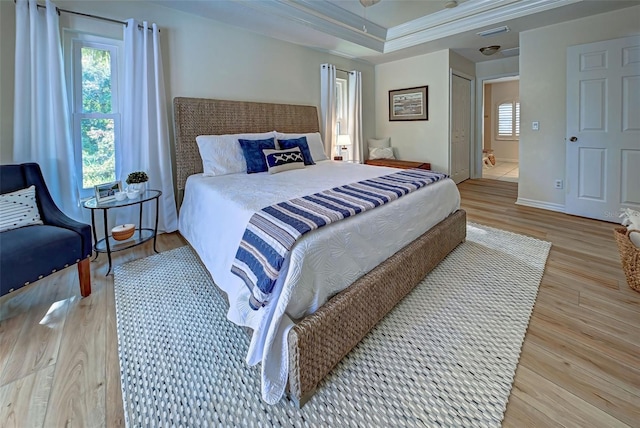 bedroom with hardwood / wood-style flooring, connected bathroom, and multiple windows