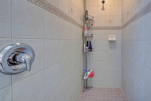 bathroom featuring a tile shower and tile walls