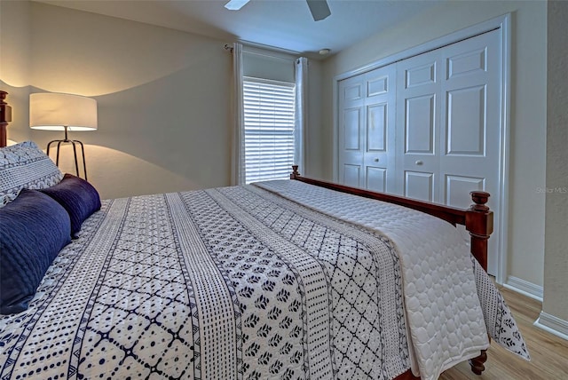 bedroom with hardwood / wood-style flooring, ceiling fan, and a closet