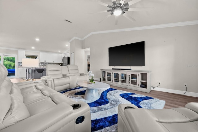 living room with hardwood / wood-style floors, ceiling fan, crown molding, and vaulted ceiling