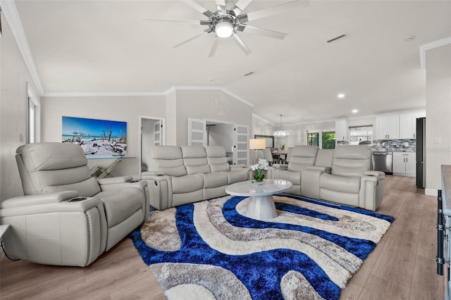 living room with ceiling fan with notable chandelier, crown molding, light wood-type flooring, and lofted ceiling