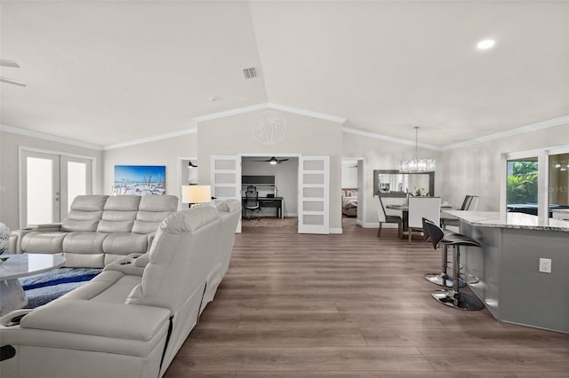 living room featuring ornamental molding, ceiling fan with notable chandelier, hardwood / wood-style floors, vaulted ceiling, and french doors