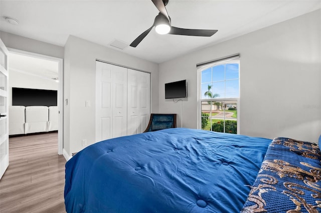 bedroom featuring hardwood / wood-style flooring, ceiling fan, and a closet