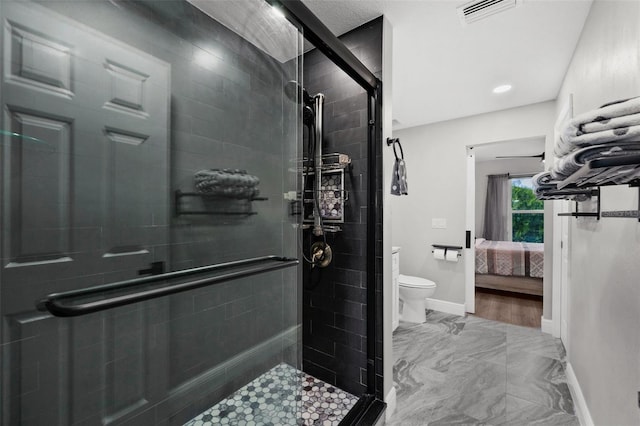 bathroom featuring toilet and an enclosed shower