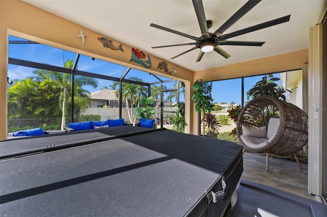 unfurnished sunroom with ceiling fan