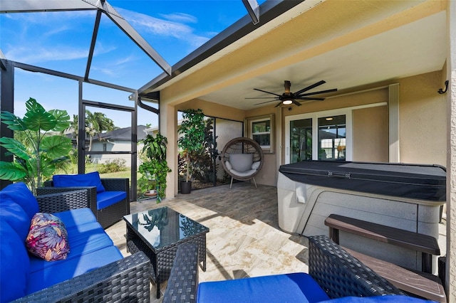 view of patio / terrace with a lanai, outdoor lounge area, ceiling fan, and a hot tub