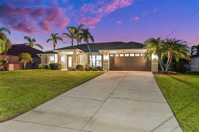 view of front of property with a garage and a yard