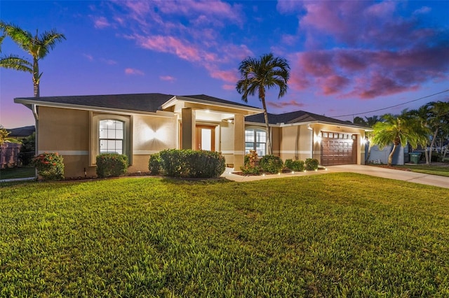 view of front of property with a garage and a lawn