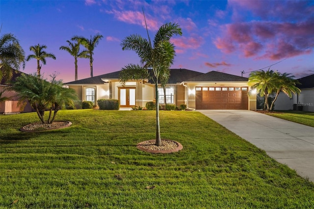 view of front of property with a garage and a lawn