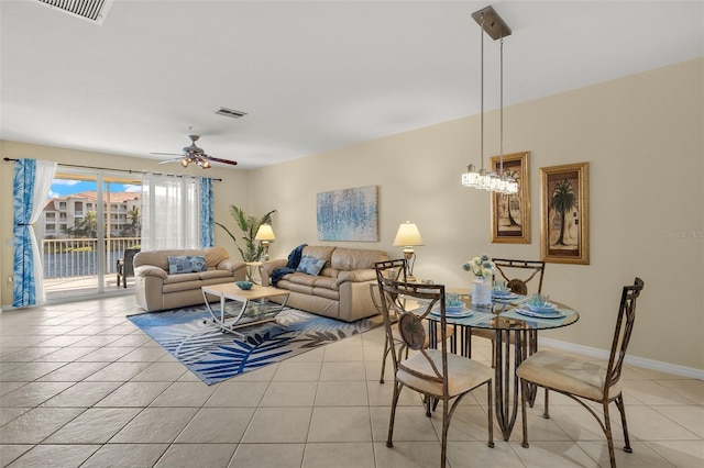 tiled living room with ceiling fan with notable chandelier