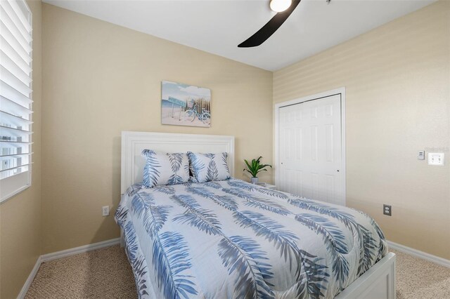 carpeted bedroom featuring ceiling fan and a closet