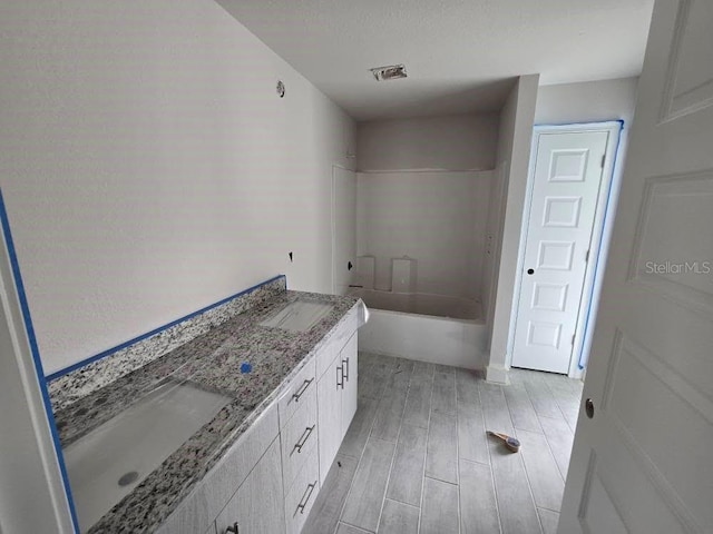 bathroom featuring double vanity, wood tiled floor, visible vents, and a sink