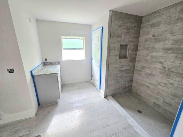 bathroom featuring a tile shower and vanity