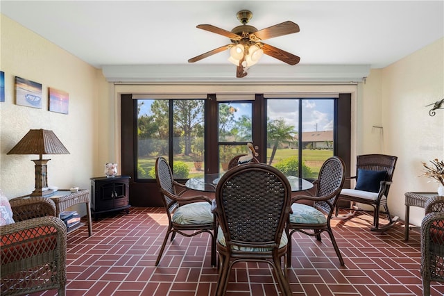 interior space with ceiling fan and a wood stove