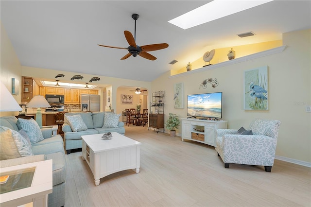 living room with light wood-type flooring, ceiling fan, and vaulted ceiling