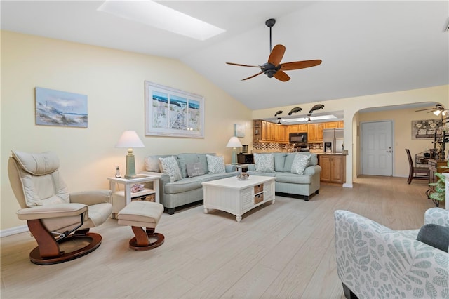 living room with lofted ceiling, ceiling fan, and light hardwood / wood-style flooring