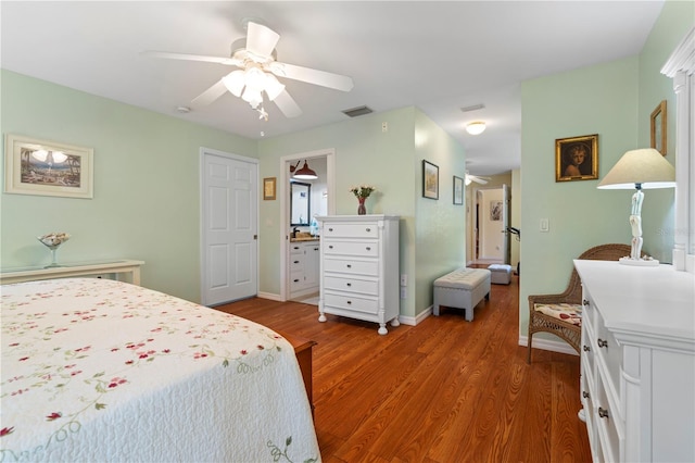 bedroom featuring ceiling fan, dark hardwood / wood-style floors, and ensuite bathroom