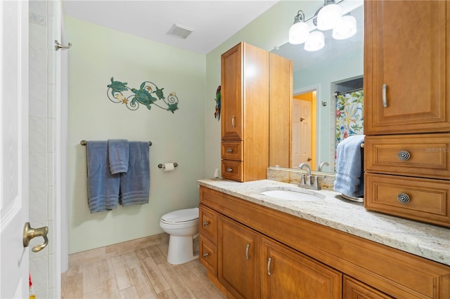 bathroom with hardwood / wood-style floors, vanity, and toilet