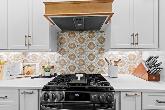 kitchen featuring white cabinets, black range, and backsplash