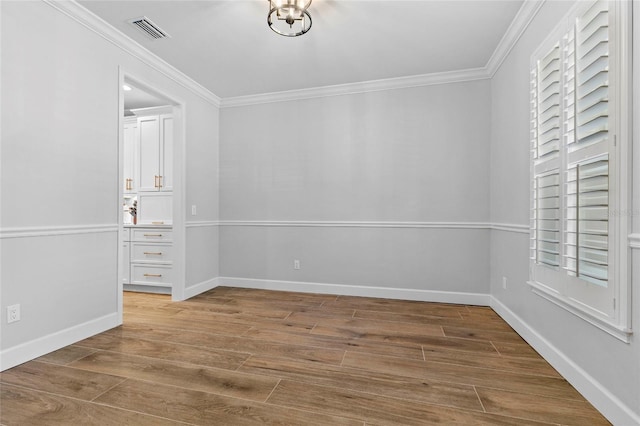 unfurnished room featuring ornamental molding and wood-type flooring