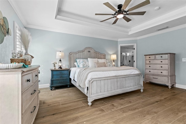 bedroom featuring ceiling fan, crown molding, a raised ceiling, and dark hardwood / wood-style flooring