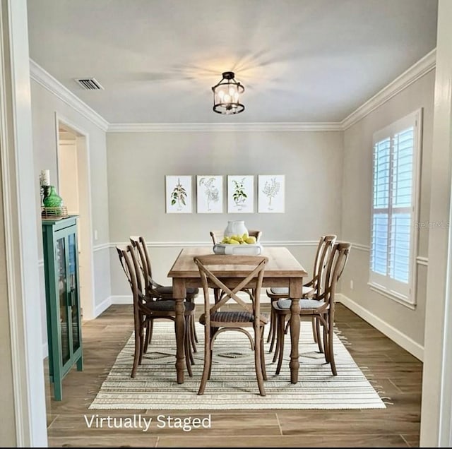 dining area featuring ornamental molding, wood-type flooring, and an inviting chandelier