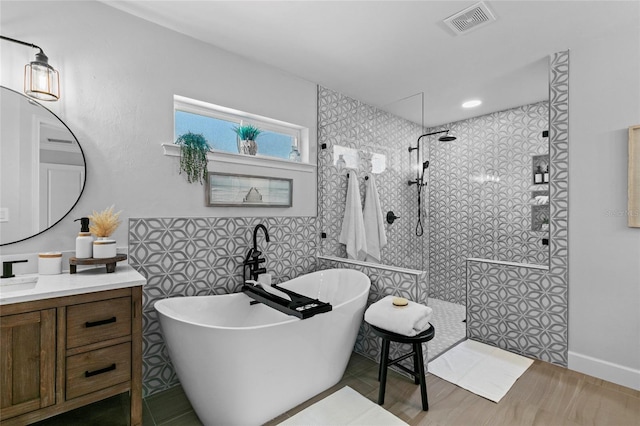 bathroom with vanity and independent shower and bath