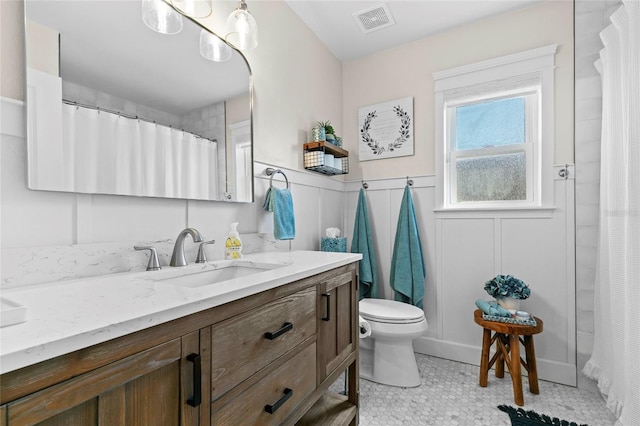 bathroom featuring curtained shower, vanity, tile patterned floors, and toilet