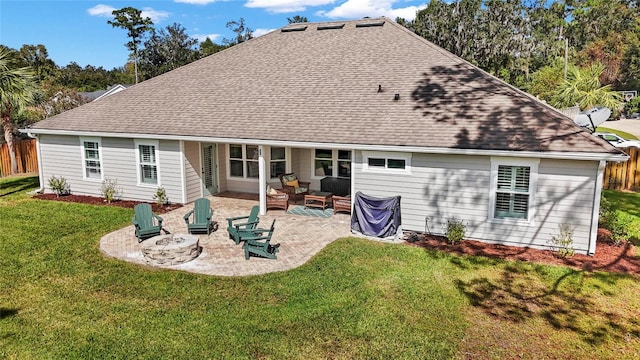 rear view of house with a patio area, a lawn, and an outdoor fire pit